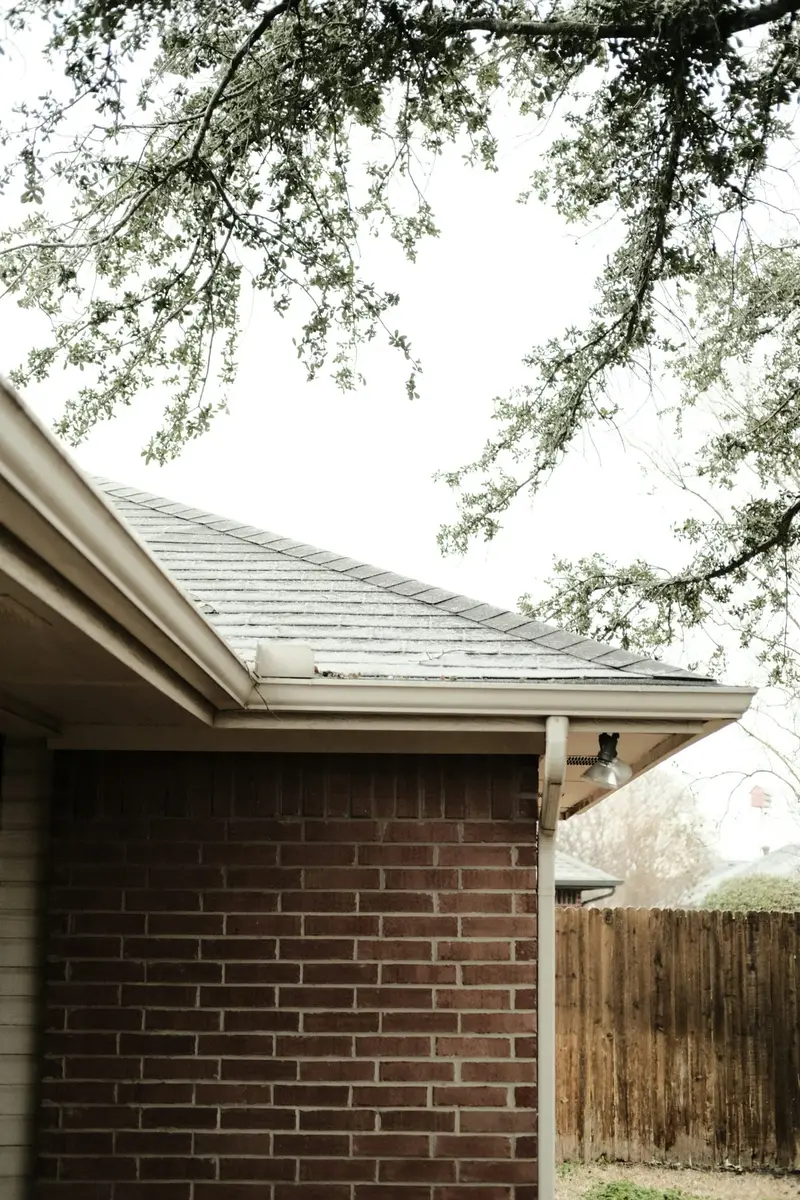 Brick house corner with gutters and a downspout