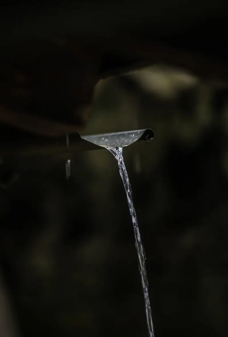 Rainwater pouring from a gutter outlet